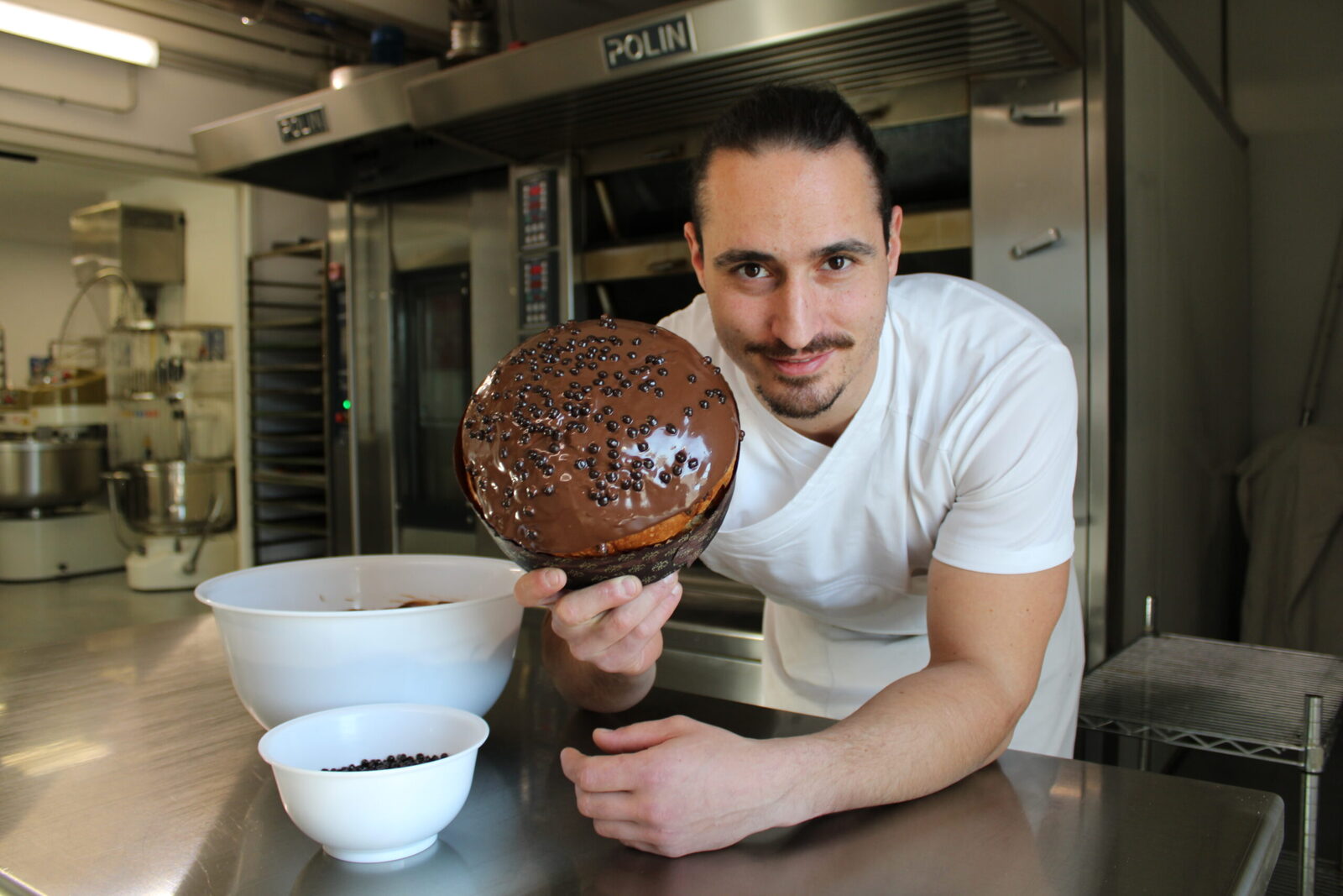 Marco Loriggiola in laboratorio, con un lievitato al cioccolato, forno alle spalle